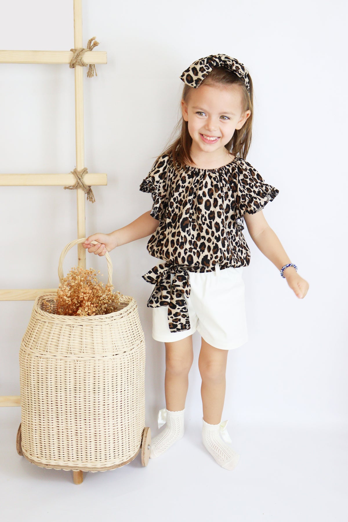 Mädchen mit Leopardenmuster Shirt und weißer kurzer Hose